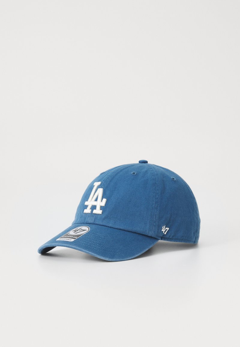 Blue baseball cap in cotton fabric features an embroidered "LA" logo in white, curved brim, and a size tag on the front.