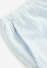 Helle blau gestreifte Baumwollstoff mit elastischem Bund und gerafftem Muster, wahrscheinlich Teil eines Kleidungsstücks oder Accessories.