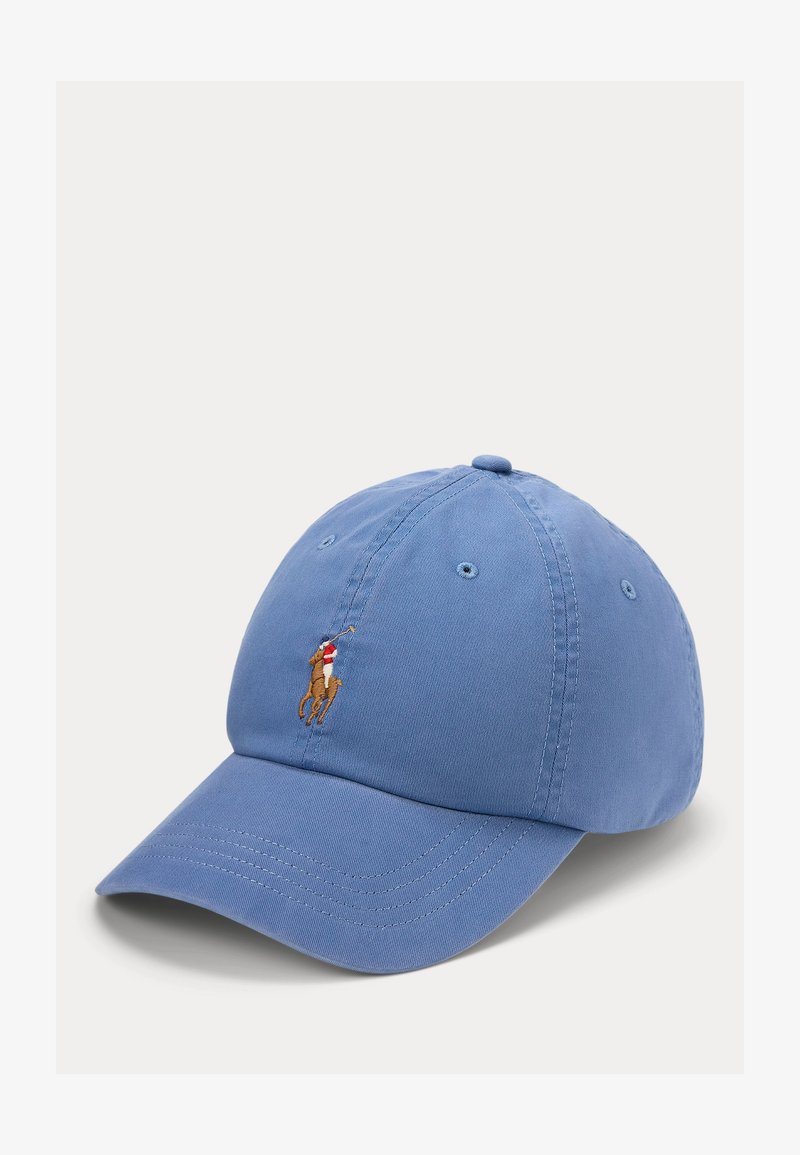 Hele sinine pesapalli nokamüts, mille esipaneelil on tikitud hobune ja ratsanik, kes hoiab polosõrmikut.