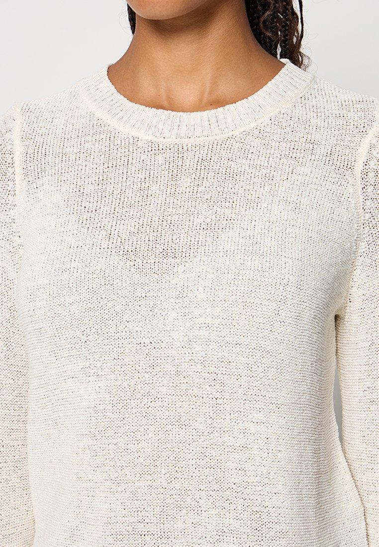 Jasna kremowa sweter, dzianinowa tekstura, okrągły dekolt, długie rękawy, lekko luźny krój, cechuje się otwartym splotem oraz miękką wykończeniem materiału.