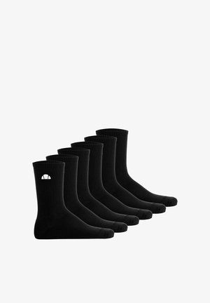 Sechs Paar schwarze Knöchelsocken mit gerippter Textur und einem kleinen weißen halbkreisförmigen Logo am Bund, nebeneinander ausgerichtet.