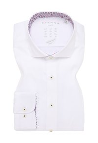 Witte slim-fit blouse, gevouwen, met een gedetailleerde gepatineerde kraagvoering in rood en blauw, voorzien van een knoopsluiting aan de voorkant en een zakdetail.