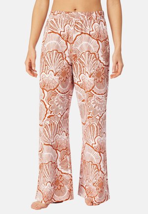 Pantalon à jambes larges avec motifs de coquillages terracotta et blancs, porté pieds nus, montrant une taille élastique et le ventre.