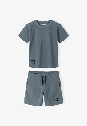 T-shirt bleu texturé à manches courtes pour enfants et shorts assortis avec un cordon noir et de petits logos rectangulaires sur les deux pièces.