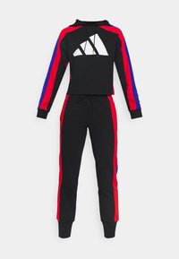 Ensemble sweat à capuche noir et jogging avec bandes latérales rouges et bleues, logo géométrique blanc sur la poitrine et taille à cordon de serrage sur le pantalon.