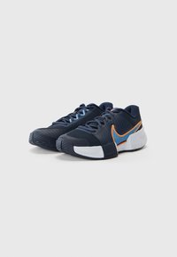 Marinefarbene Sportschuhe aus Mesh und synthetischen Materialien, mit blauen Schnürsenkeln, orangen Akzenten und einer strukturierten Gummisohle.