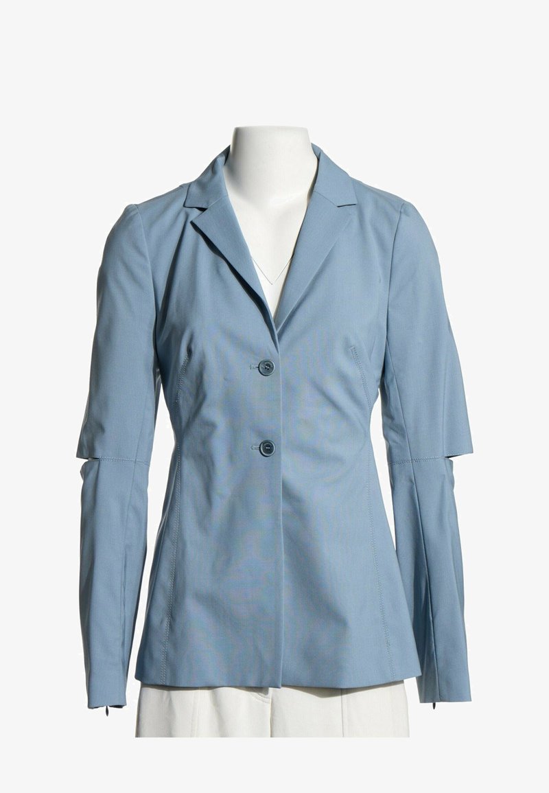 Blazer bleu clair à deux boutons et manches longues avec une découpe ouverte aux coudes, présenté sur un mannequin sans tête.
