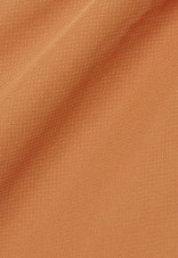 Tessuto con una trama intrecciata in una vivace tonalità arancione, caratterizzato da un sottile motivo a griglia che aggiunge profondità e interesse alla superficie.