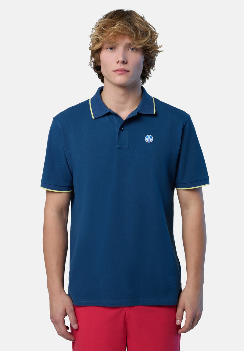 Polo shirt blu navy con rifiniture gialle, maniche corte e un piccolo logo sul petto sinistro. Realizzato in tessuto morbido.