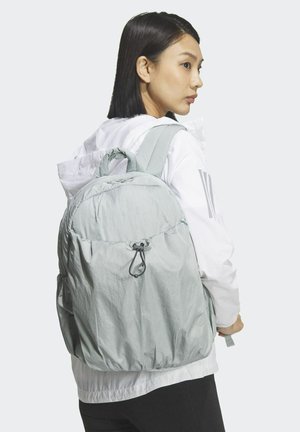 Hellgrauer Rucksack aus strukturiertem Stoff mit rundem Design, Kordelverschluss und gepolsterten Schulterriemen.