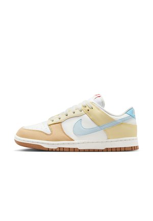 Zapatilla Nike Dunk que presenta materiales mixtos en crema, marrón, amarillo y azul claro. Cuero texturizado, cordones planos y una suela de goma.