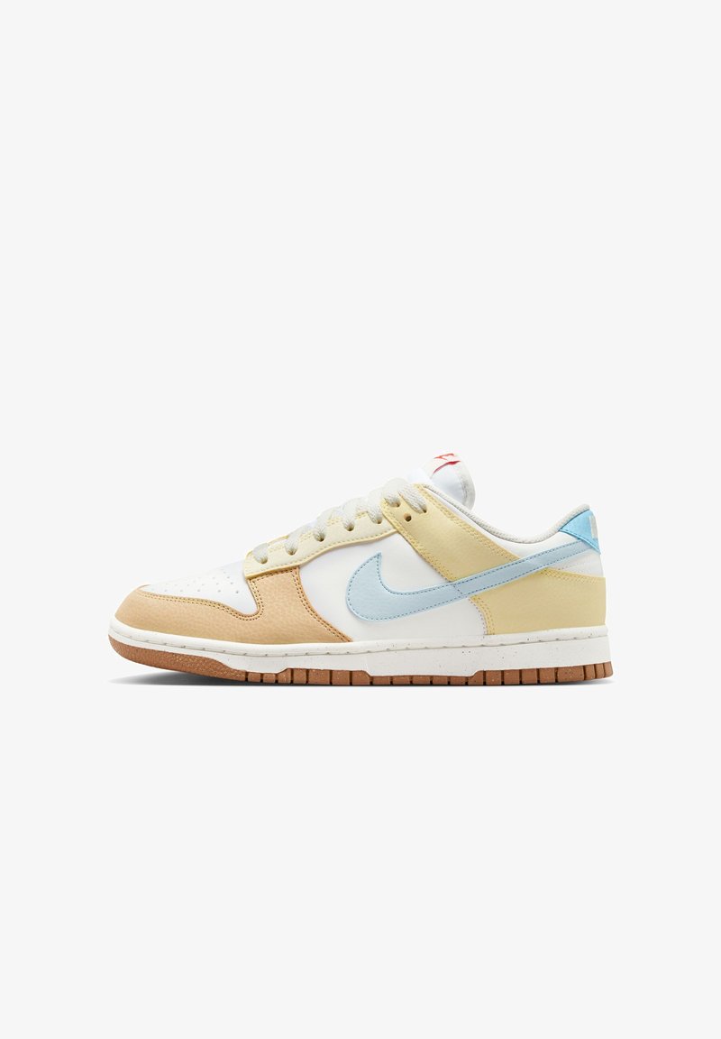 Zapatilla Nike Dunk que presenta materiales mixtos en crema, marrón, amarillo y azul claro. Cuero texturizado, cordones planos y una suela de goma.