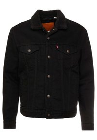 Schwarze Jeansjacke mit Sherpa-Kragen, Knopfverschluss, zwei Brusttaschen und dezenten Stickdetails. Gefüttertes Innenfutter mit warmer Textur.