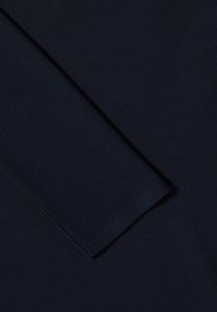 Haut bleu marine à manches longues en tissu doux et lisse. Présente un ourlet cousu et un design simple sans motifs ni ornements.