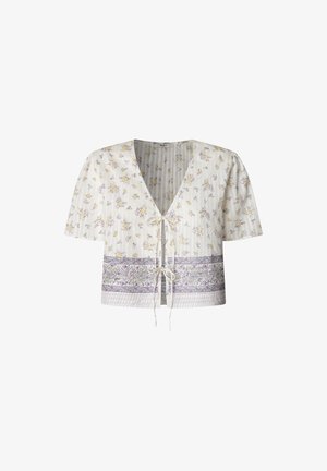 Camicia bianca corta con maniche corte, decorata con fantasie floreali nei toni del giallo e viola. Include un colletto a V e lacci frontali. Particolari a righe orizzontali.