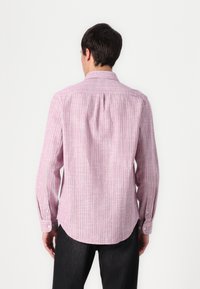 Long-sleeve shirt in pink with white and green stripes, button cuffs, and a back yoke detail, made of lightweight textured fabric.