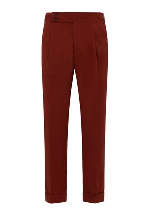 Pantaloni color ruggine con una texture liscia, caratterizzati da vita alta, chiusura con doppio bottone, pieghe e risvolti.