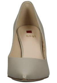 Scarpa con tacco alto beige, punta affusolata e superficie in pelle liscia. Presenta una soletta imbottita con un sottile dettaglio del logo del marchio.