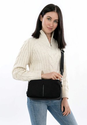 Sac à bandoulière noir avec une texture lisse, doté d'une longue sangle réglable et de deux poches zippées à l'avant.