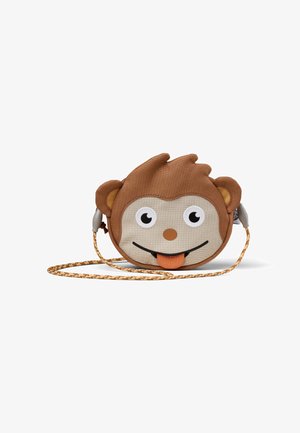 Round monkey-shaped bag made of brown fabric, with white and black eyes, an orange tongue, and a adjustable braided strap.