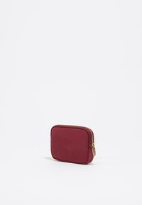 Billetera rectangular burdeos con textura suave, cremallera dorada y tirador, con un diseño minimalista y sin patrones ni acentos visibles.