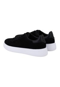 Schwarze Wildleder-Sneaker mit einer weißen Gummisohle, runden Schnürsenkeln und Lederelementen an der Ferse. Minimalistisches Design mit glatter Textur.