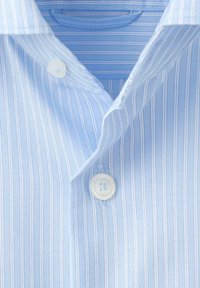 Chemise bleu clair avec fines rayures blanches verticales, boutons blancs et col plié.