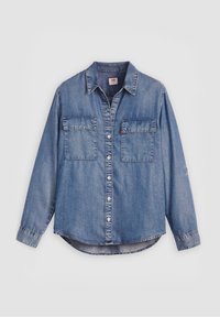 Chemise denim bleue à manches longues, boutonnée sur le devant, avec deux poches poitrine à rabats et un col classique sur un fond neutre.