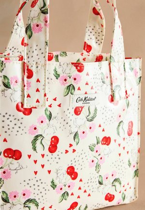 Borsa a tracolla in tessuto crema con un motivo floreale che presenta ciliegie rosse, fiori rosa, punti grigi e piccoli cuori rossi. Etichetta sul lato.