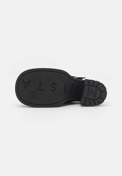 Talpa de pantof din cauciuc negru cu suprafață texturată, având modele de tracțiune și branding embossat. Formă rotunjită cu un design robust.