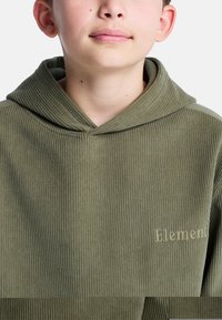 Oliwkowa bluza z korduroju z teksturowaną powierzchnią i wyszywanym logo "Element" na piersi. Posiada dużą, luźną kieszeń.