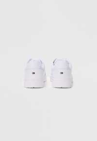 Zapatillas blancas con una parte superior sintética suave y acentos de malla texturizada. Suela de goma blanca gruesa, con un pequeño logo en el talón.