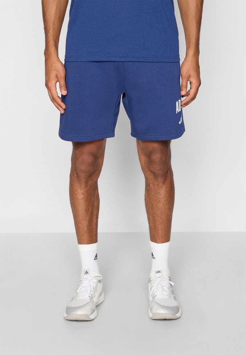 Blauwe sportshorts van zacht materiaal met een wit logodetail aan de linkerkant. Voorzien van een elastische tailleband en een klassiek model.