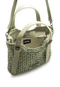 Bolso de mano tejido en verde con un exterior texturizado, acentos de cuero, correa ajustable y un bolsillo interior con cremallera con etiqueta de logo.