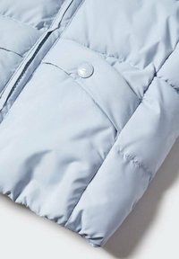 Světlomodrá prošívaná bunda se zipem a kapsou na druk.