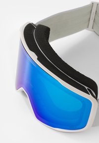 Óculos de esqui com um design curvado, apresentando uma lente azul refletora, estrutura branca e forro acolchoado preto para conforto.
