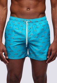 Pantaloni da bagno turchesi con un motivo di barche colorate e soli. Il materiale è liscio, con una vita regolabile tramite cordino.