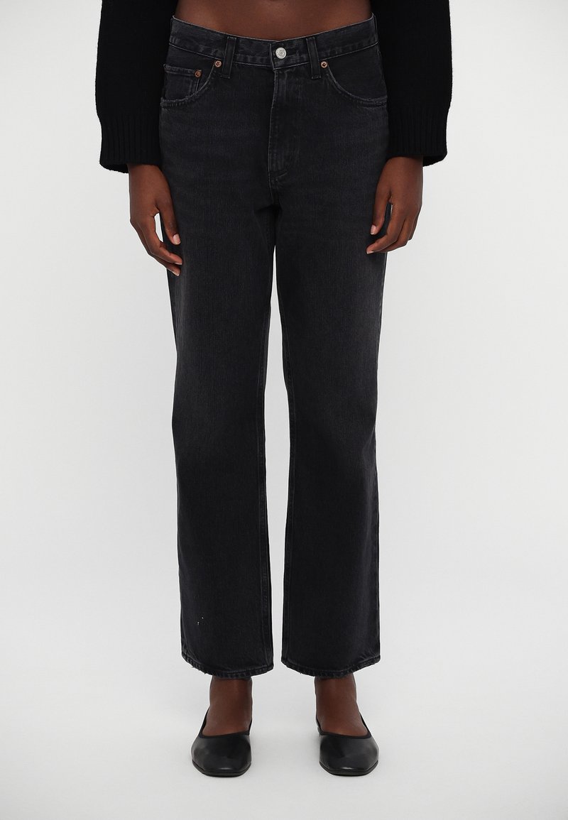Black denim jeans featuring a straight cut, high waist, and minimalistic design. Unfinished hem detail and classic five-pocket style.