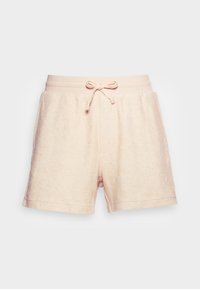 Shorts en tissu éponge rose clair avec une taille élastique côtelée et un cordon de serrage noué à l'avant sur fond blanc.