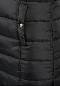 Nahaufnahme einer schwarzen Daunenjacke mit gesteppten Abschnitten, glatter Stoffoberfläche, einer Seitentasche und einem silbernen Druckknopf.