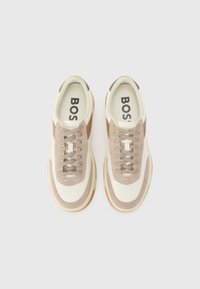 Adidași cu un brâu superior din piele crem, cu accente din suede călduț, șireturi bej, o talpă texturată și branding "BOSS" pe branțuri.