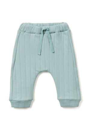 Pantalons pour bébé en bleu clair matelassé avec une taille élastique et un cordon de serrage noué, avec des poignet côtelés, posés à plat sur un fond blanc.