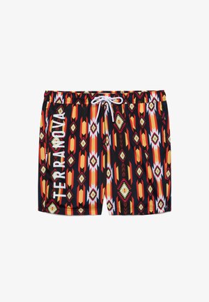 Costume da bagno con motivi geometrici tribali neri, arancioni, rossi e bianchi, coulisse bianca e testo verticale "TERRANOVA" sulla gamba sinistra.