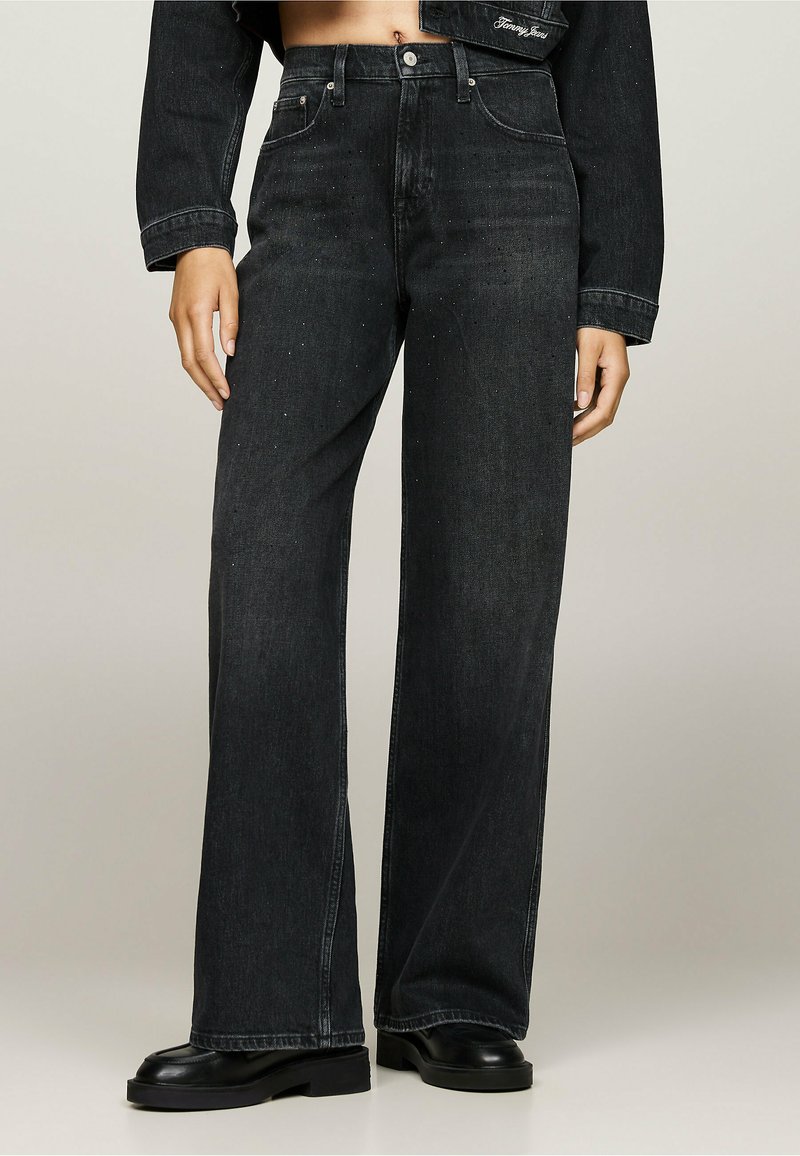 Jeans de mezclilla negros de pernera ancha con cintura alta, que cuentan con un clásico diseño de cinco bolsillos y detalles en acero inoxidable.