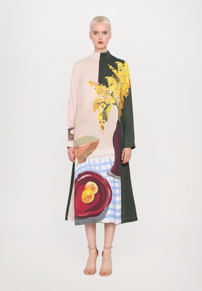 Rochie lungă, cu blocuri de culoare, prezentând imprimeuri florale și de natură moartă în nuanțe de roz, verde, galben și albastru, cu un guler înalt și o croială lejeră.