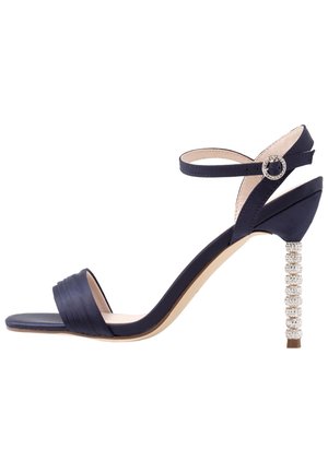 Marinblå klack sandalett med satinfinish, med en plisserad tårem och en prydlig blockklack med kristaller. Justerbar ankelrem ingår.