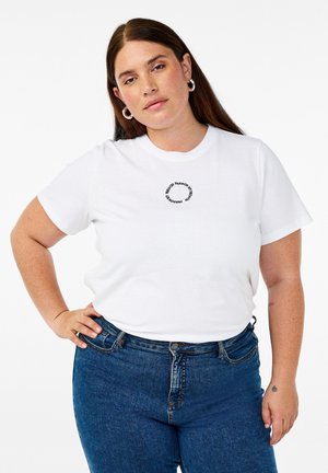 T-shirt en coton blanc à manches courtes, avec un design graphique de texte noir circulaire au niveau de la poitrine. Associé à un jean en denim bleu.