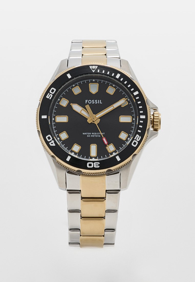 Orologio Fossil con quadrante nero, dettagli dorati e bracciale in metallo argentato. Presenta indicatori luminosi e resistenza all'acqua fino a 50 metri.