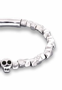 Pulsera de plata con formas de cuentas pulidas e irregulares y una calavera central con detalles negros en los ojos. Textura lisa y reflectante.