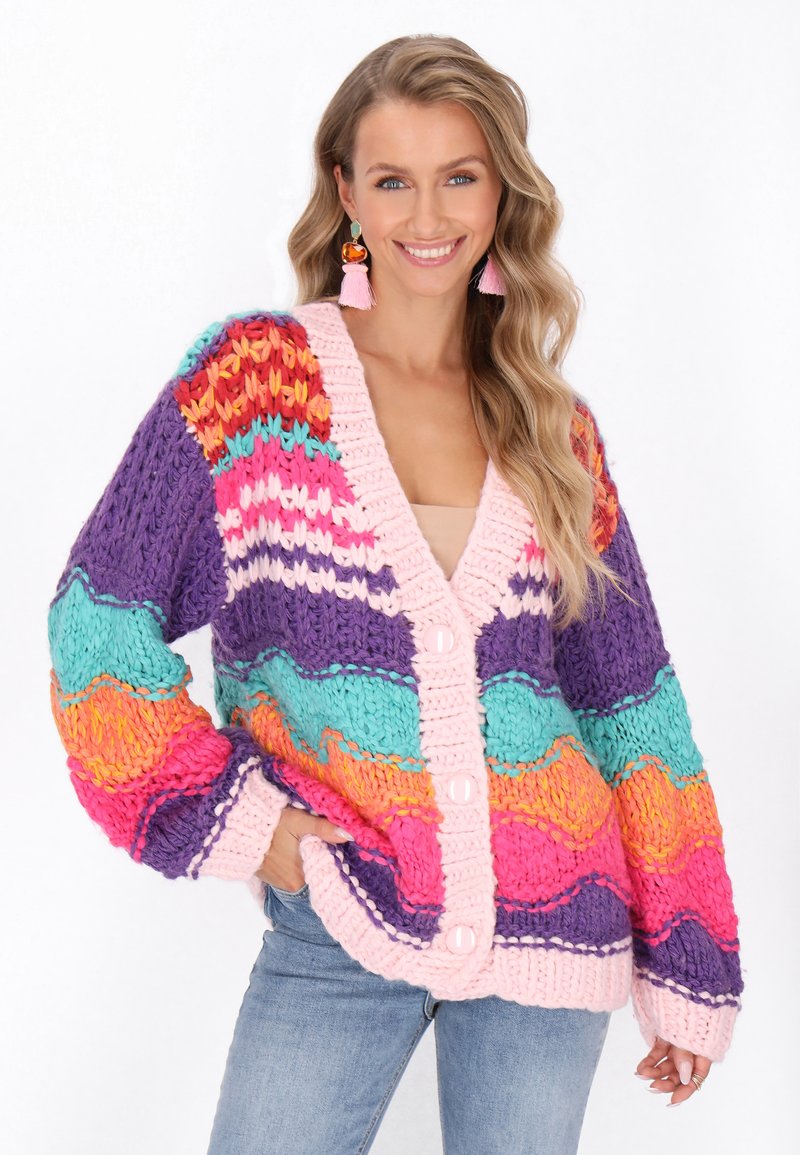 Flerfärgad stickad cardigan med böljande mönster i rosa, orange, lila och teal, med knappar i rosa framtill och ribbade ärmslut.